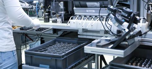 Eine Mitarbeiterin vor eine Maschine in der Montage bei Magnetbau Schramme
